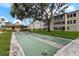 Recreational area with a shuffleboard court, surrounded by mature trees and lush landscaping at 11620 Park Blvd # 306, Seminole, FL 33772