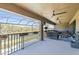 Covered balcony with outdoor seating overlooking serene lake and greenery at 13019 Wildflower Meadow Dr, Riverview, FL 33579