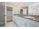 Bright bathroom featuring dual sinks with granite countertops and view into the bedroom at 13019 Wildflower Meadow Dr, Riverview, FL 33579