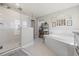 Bright bathroom featuring a walk-in shower, soaking tub, and an open doorway to the large walk-in closet at 13019 Wildflower Meadow Dr, Riverview, FL 33579