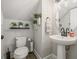 Cozy half bathroom with pedestal sink, toilet, and charming decorative plants at 13019 Wildflower Meadow Dr, Riverview, FL 33579