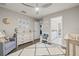 Charming Bedroom with a white dresser, grey chair, crib, light-colored rug, and plenty of natural light at 13019 Wildflower Meadow Dr, Riverview, FL 33579