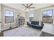 Bright bedroom featuring large windows, a blue sofa, light-colored rug and built-in bookshelf at 13019 Wildflower Meadow Dr, Riverview, FL 33579