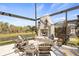 Outdoor living space featuring a stone fireplace, Adirondack chairs and view of the adjacent pond at 13019 Wildflower Meadow Dr, Riverview, FL 33579