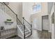 Bright foyer boasts soaring ceilings, decorative chandelier, staircase, and ornate glass front door at 13019 Wildflower Meadow Dr, Riverview, FL 33579