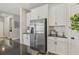 Close up of the kitchen featuring stainless steel refrigerator with white cabinets and dark countertops at 13019 Wildflower Meadow Dr, Riverview, FL 33579