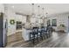 Modern kitchen with stainless appliances, white cabinetry, a breakfast bar, and wood-look flooring at 13019 Wildflower Meadow Dr, Riverview, FL 33579