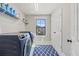 Well-organized laundry room features navy appliances, white cabinets, and a window with a neighborhood view at 13019 Wildflower Meadow Dr, Riverview, FL 33579