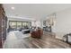 Spacious living room with hardwood floors, leather furniture, and access to the balcony at 13019 Wildflower Meadow Dr, Riverview, FL 33579
