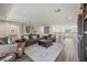 Spacious living room with an open layout, leather furniture, hardwood floors, and great natural lighting at 13019 Wildflower Meadow Dr, Riverview, FL 33579
