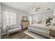Serene bedroom with large windows, decorative wall art, a cozy bed, and neutral color palette at 13019 Wildflower Meadow Dr, Riverview, FL 33579