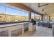A covered outdoor kitchen with a grill, beverage cooler, bar, and ample counter space, all within a screened lanai at 13019 Wildflower Meadow Dr, Riverview, FL 33579
