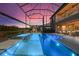 A beautiful pool and spa are surrounded by a screened enclosure with a fireplace and outdoor seating at 13019 Wildflower Meadow Dr, Riverview, FL 33579