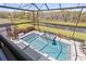 A beautiful pool with a built-in hot tub overlooks a large pond and wooded preserve at 13019 Wildflower Meadow Dr, Riverview, FL 33579