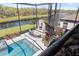Aerial view of a luxurious pool and outdoor living space including fireplace and screened in patio at 13019 Wildflower Meadow Dr, Riverview, FL 33579