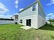 Home's backyard featuring green lawn, partial view of house with sliding glass door to patio at 13118 Zolo Springs Cir, Riverview, FL 33579