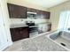 Kitchen with dark cabinetry, stainless steel appliances, and granite countertops at 13118 Zolo Springs Cir, Riverview, FL 33579
