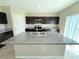 Kitchen island with granite countertops, stainless steel appliances, and dark cabinets at 13118 Zolo Springs Cir, Riverview, FL 33579