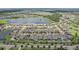 Panoramic aerial view showcasing a well-developed residential community with numerous homes surrounding a tranquil lake at 13128 Foxtail Fern Dr, Riverview, FL 33579