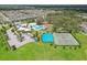 Aerial view showcases community amenities including swimming pools, clubhouse, sports courts, and surrounding residences at 13128 Foxtail Fern Dr, Riverview, FL 33579