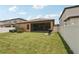 This home includes a spacious backyard with lush green grass, a grill, and a screened patio at 13128 Foxtail Fern Dr, Riverview, FL 33579