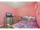 This cozy pink bedroom is perfect for a , complete with a doll house and a bed with colorful sheets at 13128 Foxtail Fern Dr, Riverview, FL 33579