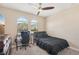 This bedroom features a ceiling fan, carpet floors, a bed, a desk, and two windows for plenty of natural light at 13128 Foxtail Fern Dr, Riverview, FL 33579