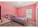 This cozy pink bedroom is perfect for a , complete with a doll house and a bed with colorful sheets at 13128 Foxtail Fern Dr, Riverview, FL 33579
