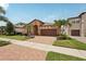 Attractive single-story home with a brick driveway, complemented by palm trees and a manicured lawn at 13128 Foxtail Fern Dr, Riverview, FL 33579