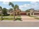 Charming single-story home with a well-manicured lawn, lush landscaping, and a brick-paved driveway at 13128 Foxtail Fern Dr, Riverview, FL 33579
