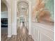 Elegant hallway featuring wood-look tile flooring, arched entryways and decorative wainscoting at 13128 Foxtail Fern Dr, Riverview, FL 33579