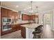 Spacious kitchen featuring an island with seating, wooden cabinets, and stainless steel appliances at 13128 Foxtail Fern Dr, Riverview, FL 33579