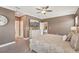 Well-lit main bedroom showing a dresser, a large ceiling fan, and an open doorway at 13128 Foxtail Fern Dr, Riverview, FL 33579