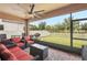 Relax on this screened patio with cozy seating, a ceiling fan, and views of the fenced backyard at 13128 Foxtail Fern Dr, Riverview, FL 33579