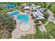 Aerial view of a community pool and clubhouse with multiple seating areas, a playground, and lush landscaping at 13128 Foxtail Fern Dr, Riverview, FL 33579