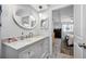 Bright bathroom featuring a white marble vanity, oval mirror, and modern fixtures at 1641 Jeffords St, Clearwater, FL 33756