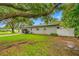 Home exterior with a well-maintained yard, white fence, and mature trees providing ample shade at 1641 Jeffords St, Clearwater, FL 33756