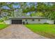 Single-story house with a brick-paved driveway, garage, well-maintained lawn, and an American flag at 1641 Jeffords St, Clearwater, FL 33756
