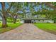 Charming single-story home featuring a paver driveway, mature trees, and a well-manicured lawn at 1641 Jeffords St, Clearwater, FL 33756