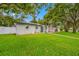 Charming single-story home with manicured lawn, mature trees, and an American flag at 1641 Jeffords St, Clearwater, FL 33756