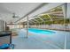 Enclosed pool area with ample deck space, covered patio, ceiling fans, and lush landscaping around the perimeter at 1641 Jeffords St, Clearwater, FL 33756