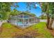 Backyard showcasing a screened-in pool enclosure with ample seating, surrounded by lush landscaping and a well-kept lawn at 1641 Jeffords St, Clearwater, FL 33756