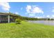 Scenic backyard featuring a screened lanai, expansive lawn, and a tranquil lake view at 16898 Balance Cv, Land O Lakes, FL 34638