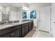 Bathroom boasts a double sink vanity with granite countertops, dark cabinets, and a large mirror at 16898 Balance Cv, Land O Lakes, FL 34638