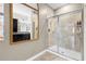 Well-lit bathroom with a glass-enclosed shower and sleek vanity with decorative mirror at 16898 Balance Cv, Land O Lakes, FL 34638