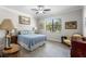 Comfortable bedroom featuring a ceiling fan, light gray walls, wood-look flooring, and a window with outside views at 16898 Balance Cv, Land O Lakes, FL 34638