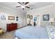 This bedroom offers a ceiling fan, light gray walls, wood-look flooring, and a connected door to a bathroom at 16898 Balance Cv, Land O Lakes, FL 34638