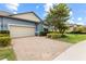 Charming single-Gathering home boasts a brick driveway, two-car garage, and lush landscaping at 16898 Balance Cv, Land O Lakes, FL 34638