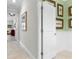 Hallway with art displays, leading to a bedroom and bathroom, featuring white trim at 16898 Balance Cv, Land O Lakes, FL 34638