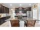 This stunning kitchen has an island with granite countertops and stainless steel appliances that complement the dark cabinets at 16898 Balance Cv, Land O Lakes, FL 34638